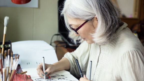 a senior woman doing painting