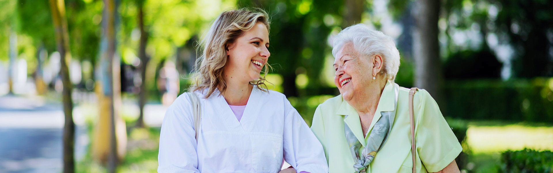 female caregiver with elderly woman smiling