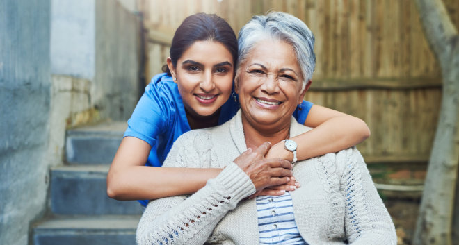 female caregiver with an elderly woman smiling