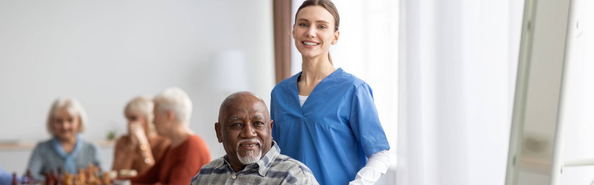 female caregiver and elderly man smiling