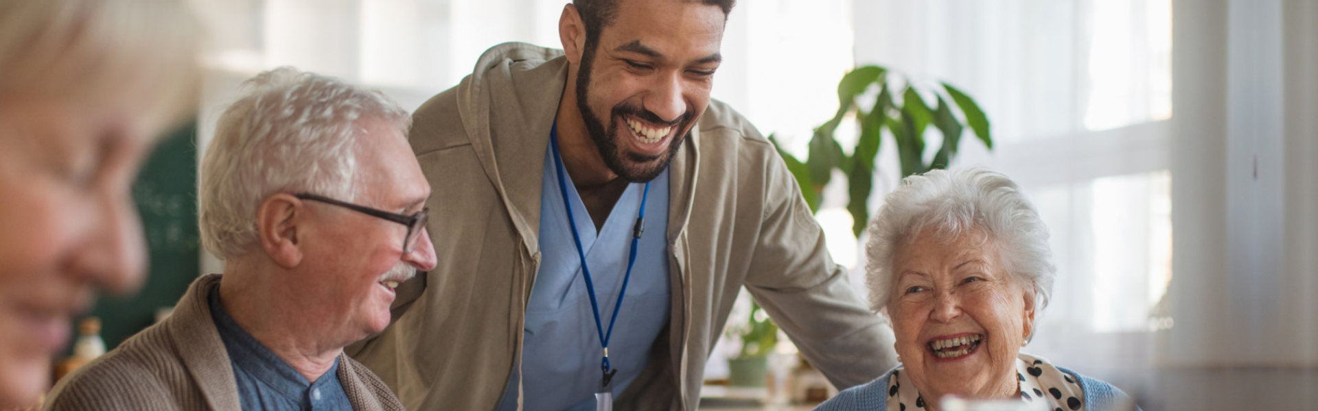 male caregiver smiling with elderlies